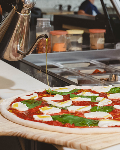 Pouring sauce on pizza