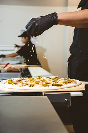 Sprinkling cheese on pizza